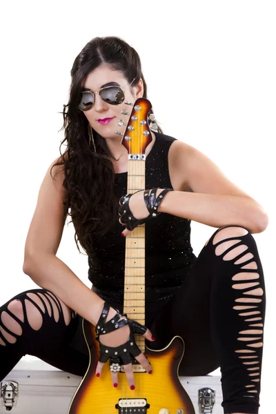 Beautiful girl in dark leather clothes holding an electric guitar — Stock Photo, Image