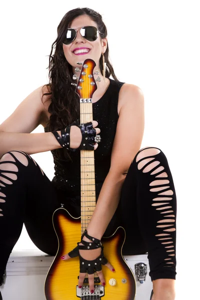 अंधेरे चमड़े के कपड़े में सुंदर लड़की एक इलेक्ट्रिक गिटार पकड़े हुए — स्टॉक फ़ोटो, इमेज