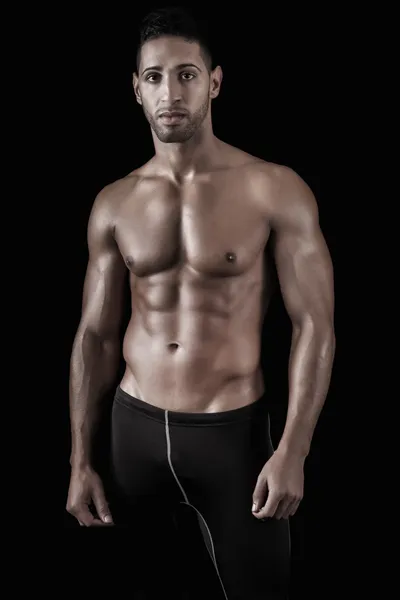 Uomo muscoloso su uno sfondo nero — Foto Stock