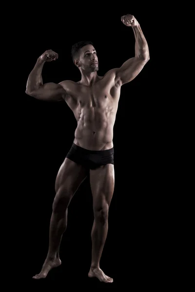 Uomo muscoloso su uno sfondo nero — Foto Stock