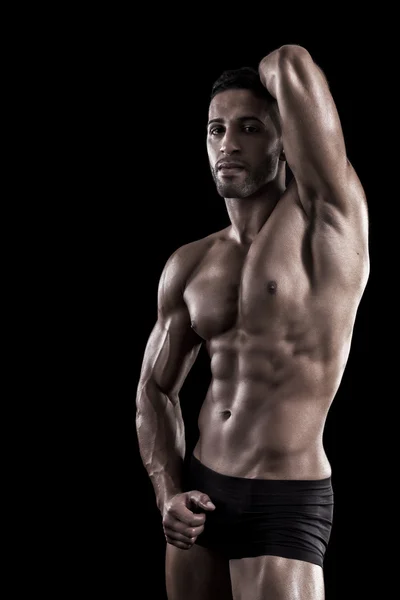 Muskulöser Mann auf schwarzem Hintergrund — Stockfoto