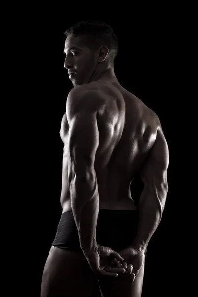 Muscled man on a black background — Stock Photo, Image