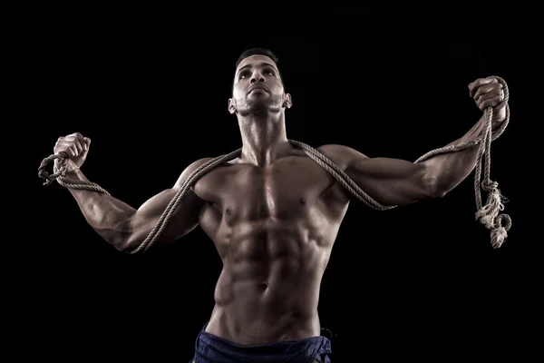 Hombre musculoso sobre un fondo negro — Foto de Stock