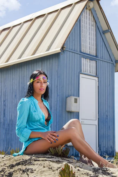 Schönes Mädchen am Strand neben einem blauen Holzhaus — Stockfoto