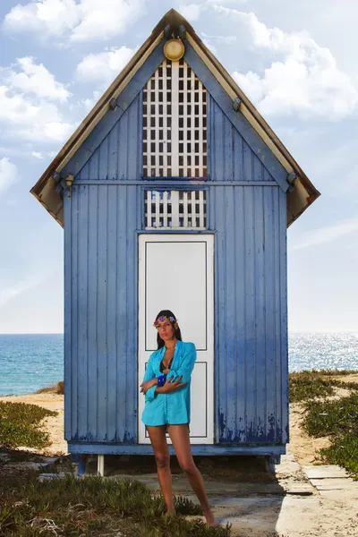 Bella ragazza in spiaggia accanto a una casa di legno blu — Foto Stock