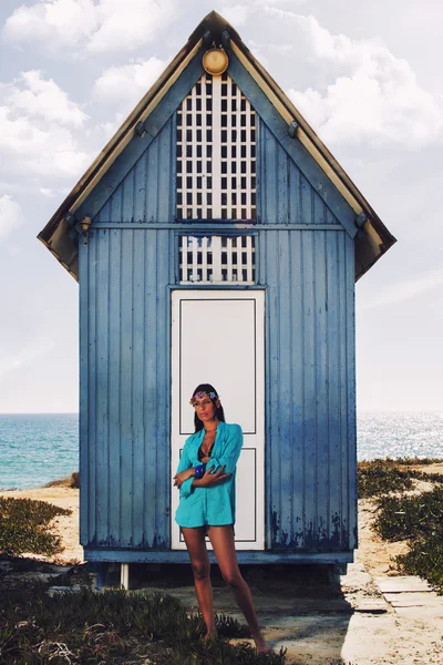 Belle fille dans la plage à côté d'une maison en bois bleu — Photo