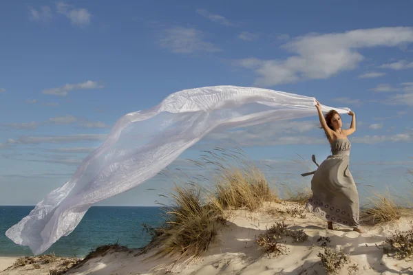 Gyönyörű lány a strandon, szép hosszú fehér ruhával — Stock Fotó