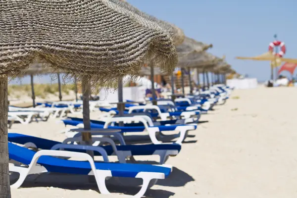 Strandstoelen met stro paraplu 's — Stockfoto