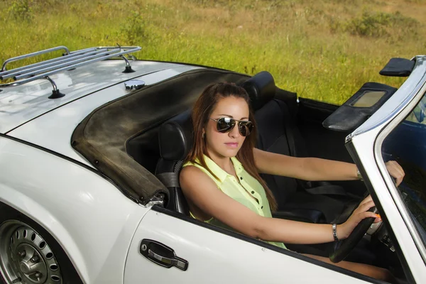 Vacker kvinna poserar på en vit cabriolet bil — Stockfoto