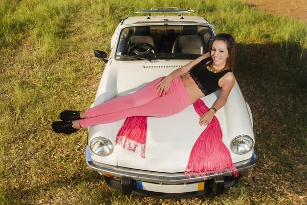 Hermosa mujer posando en un coche convertible blanco — Foto de Stock