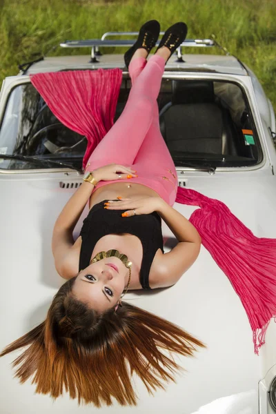 Beautiful woman posing on a white convertible car — Stock Photo, Image