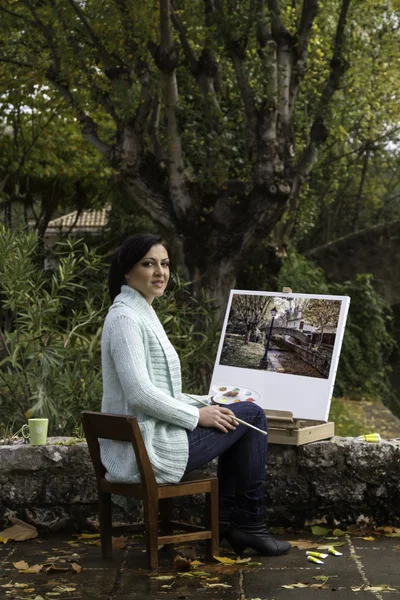 Jonge vrouw schilderij op een park — Stockfoto