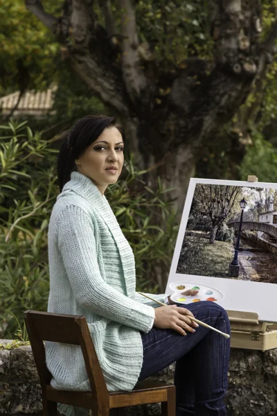 Jonge vrouw schilderij op een park — Stockfoto