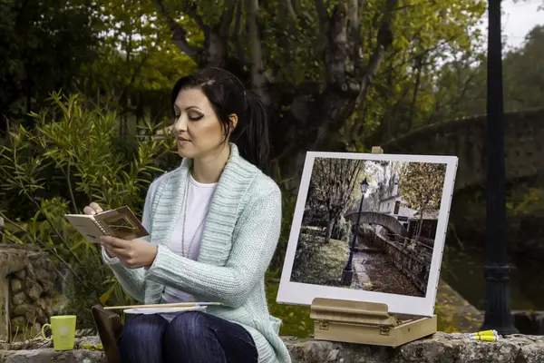 Νεαρή γυναίκα ζωγραφική σε ένα πάρκο — Φωτογραφία Αρχείου