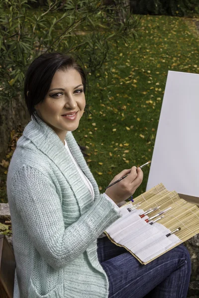 Jonge vrouw schilderij op een park — Stockfoto