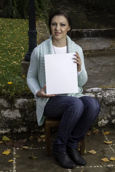 Young woman holding a blank canvas — Stock Photo, Image