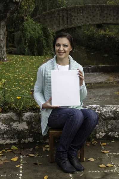 Young woman holding a blank canvas — Stock Photo, Image