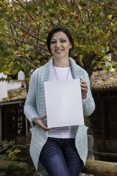 Mujer joven sosteniendo un lienzo en blanco — Foto de Stock