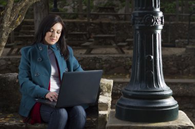 Dizüstü bilgisayarda çalışan genç bir kadın