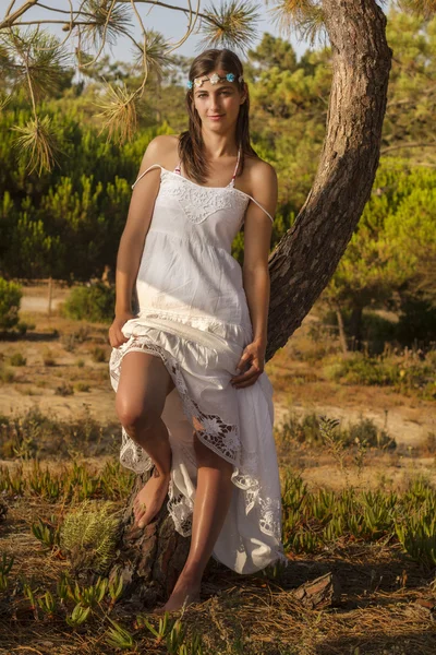 Młoda dziewczyna z długą białą sukienkę w lesie. — Zdjęcie stockowe