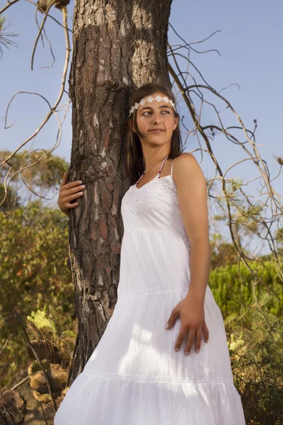 Ung flicka med en lång vit klänning i skogen. — Stockfoto