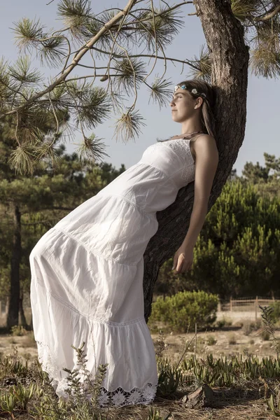 Jovem com um longo vestido branco na árvore — Fotografia de Stock