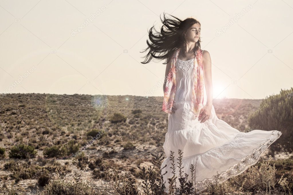 Young girl with a long white dress and scarf outdoor