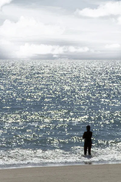 Ensam figur stirrar på havet — Stockfoto