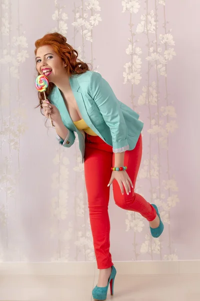 Beautiful redhead girl with a lollipop candy — Stock Photo, Image