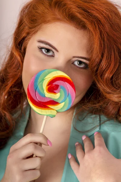 棒付きキャンディーと美しい赤毛の女の子 — ストック写真