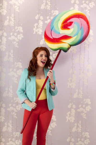 Beautiful redhead girl with a lollipop candy — Stock Photo, Image