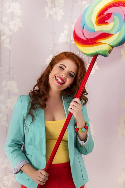 Mooi roodharig meisje met een lolly snoep — Stockfoto