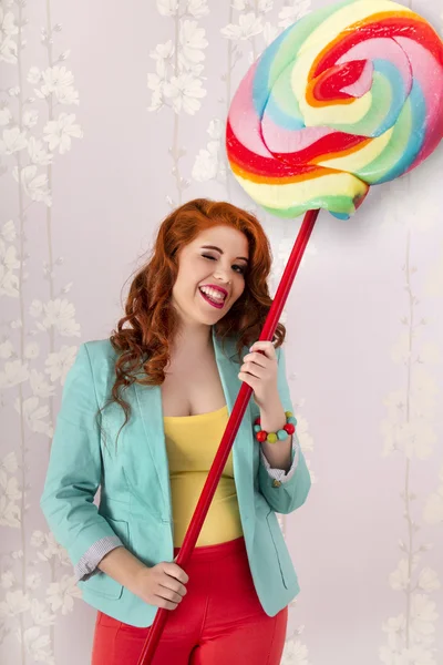 Beautiful redhead girl with a lollipop candy — Stock Photo, Image