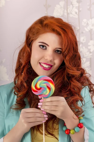 Hermosa chica pelirroja con un caramelo piruleta — Foto de Stock