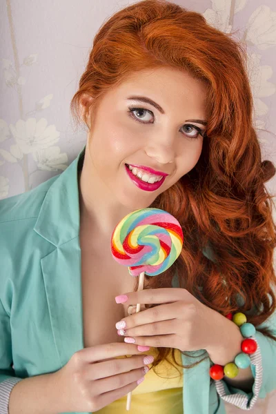 Schöne rothaarige Mädchen mit einem Lutscher Süßigkeiten — Stockfoto