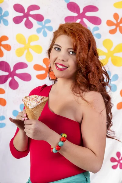 Hermosa pelirroja usando ropa colorida sosteniendo un helado — Foto de Stock