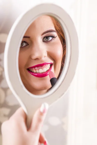 Beautiful redhead girl applying lipstick — Stock Photo, Image