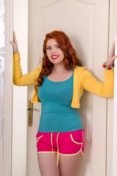 Beautiful redhead girl with colorful clothes in her bedroom — Stock Photo, Image