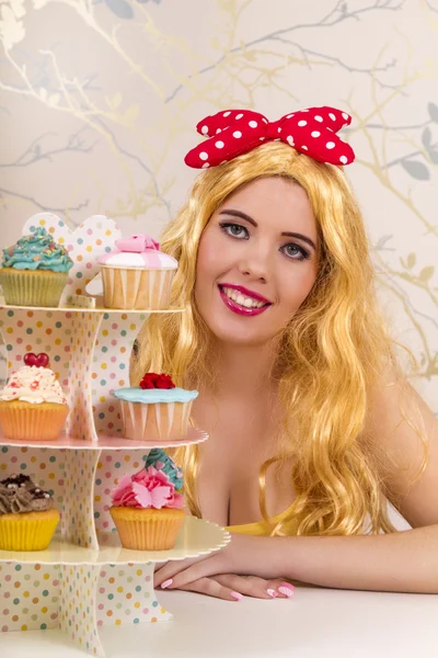 Hermosa chica pelirroja pinup con cupcakes de colores —  Fotos de Stock