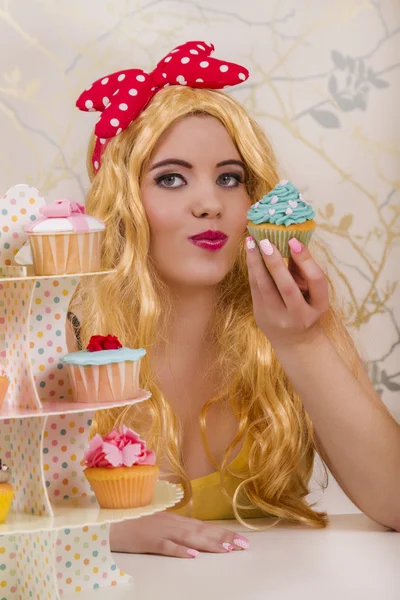 Hermosa chica pelirroja pinup con cupcakes de colores — Foto de Stock