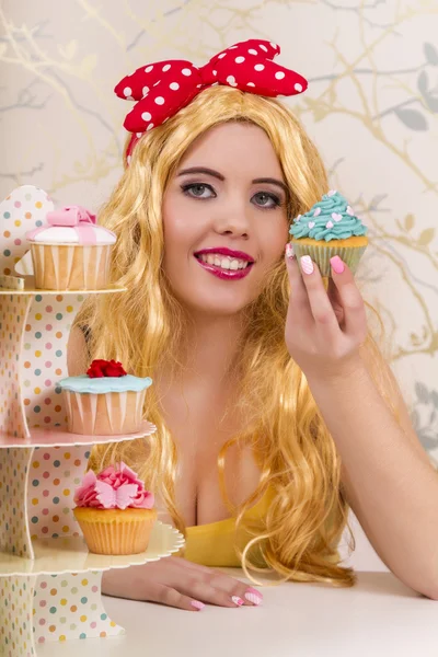 Vackra pinup rödhårig tjej med färgglada cupcakes — Stockfoto