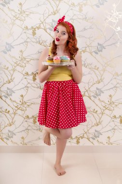 renkli kek bir tepsi tutarak güzel pinup Kızıl saçlı kız