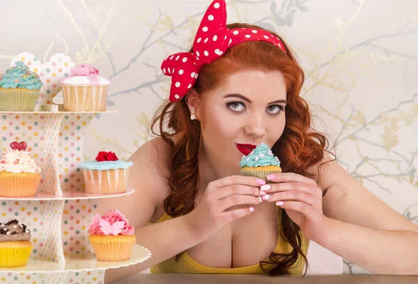 Vackra pinup rödhårig tjej med färgglada cupcakes — Stockfoto