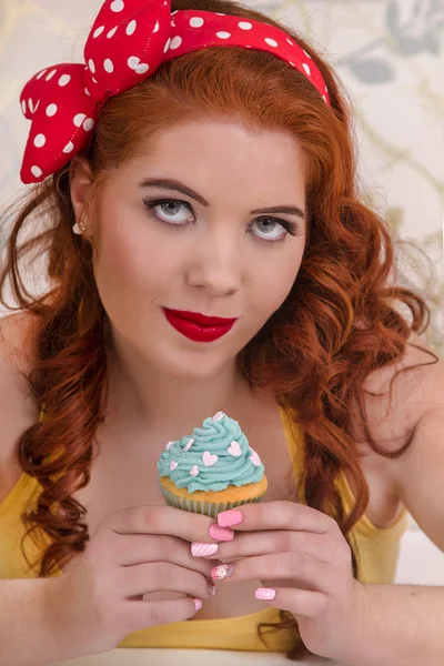 Vackra pinup rödhårig tjej med färgglada cupcakes — Stockfoto