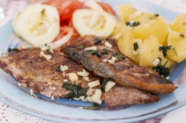 Portekiz yemeği ızgara ton balığı, göbekli balık, patates ve domates salatası..