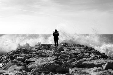 Dalgalanan sularda yalnız bir kadın, sahile yakın şiddetli dalgalarla karşı karşıya..