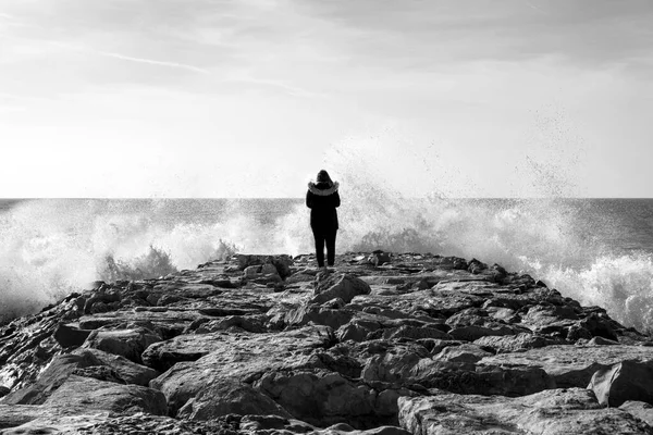 Osamělá Žena Vlnolamu Čelí Prudkým Stříkajícím Vlnám Blízkosti Pláže — Stock fotografie