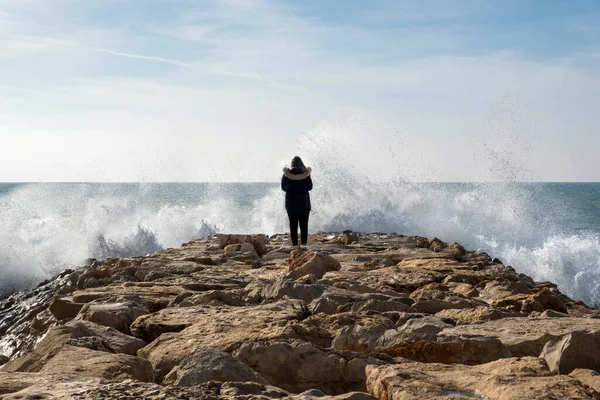 Osamělá Žena Vlnolamu Čelí Prudkým Stříkajícím Vlnám Blízkosti Pláže — Stock fotografie