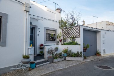Algarve bölgesi binalarının tipik mimarisi dar sokaklar, kaldırım taşı caddeleri çiçekler, vazolar, renkler ve bacalarla süslenmiş..