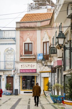 OLHAO, PORTUGAL - 13 Şubat 2022: Platformların karmaşık tasarımları ve dar kaldırımlı caddeleri olan Algarve kırsal binalarının tipik mimarisi.